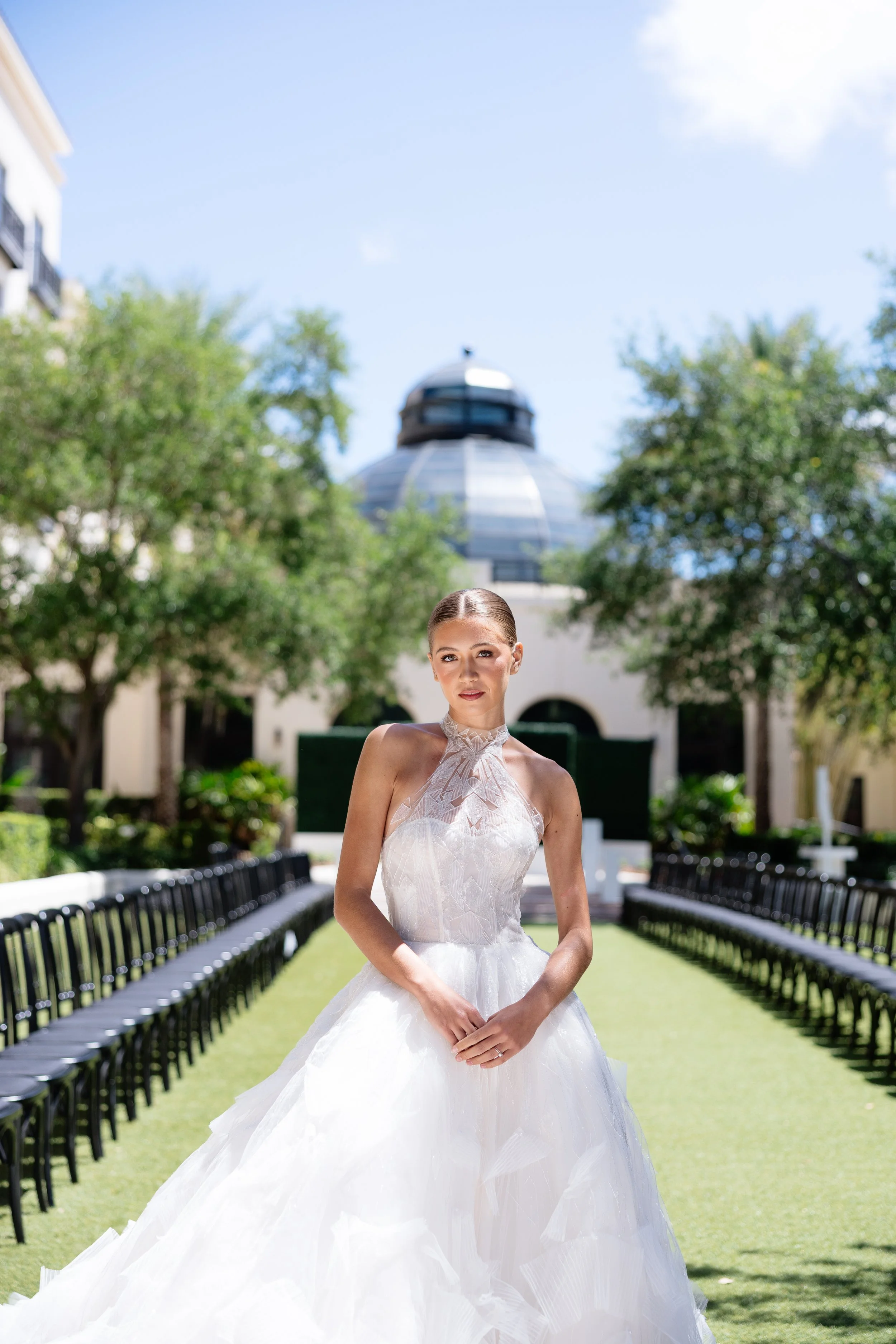 A woman in a intricate lace ballgown is posing.