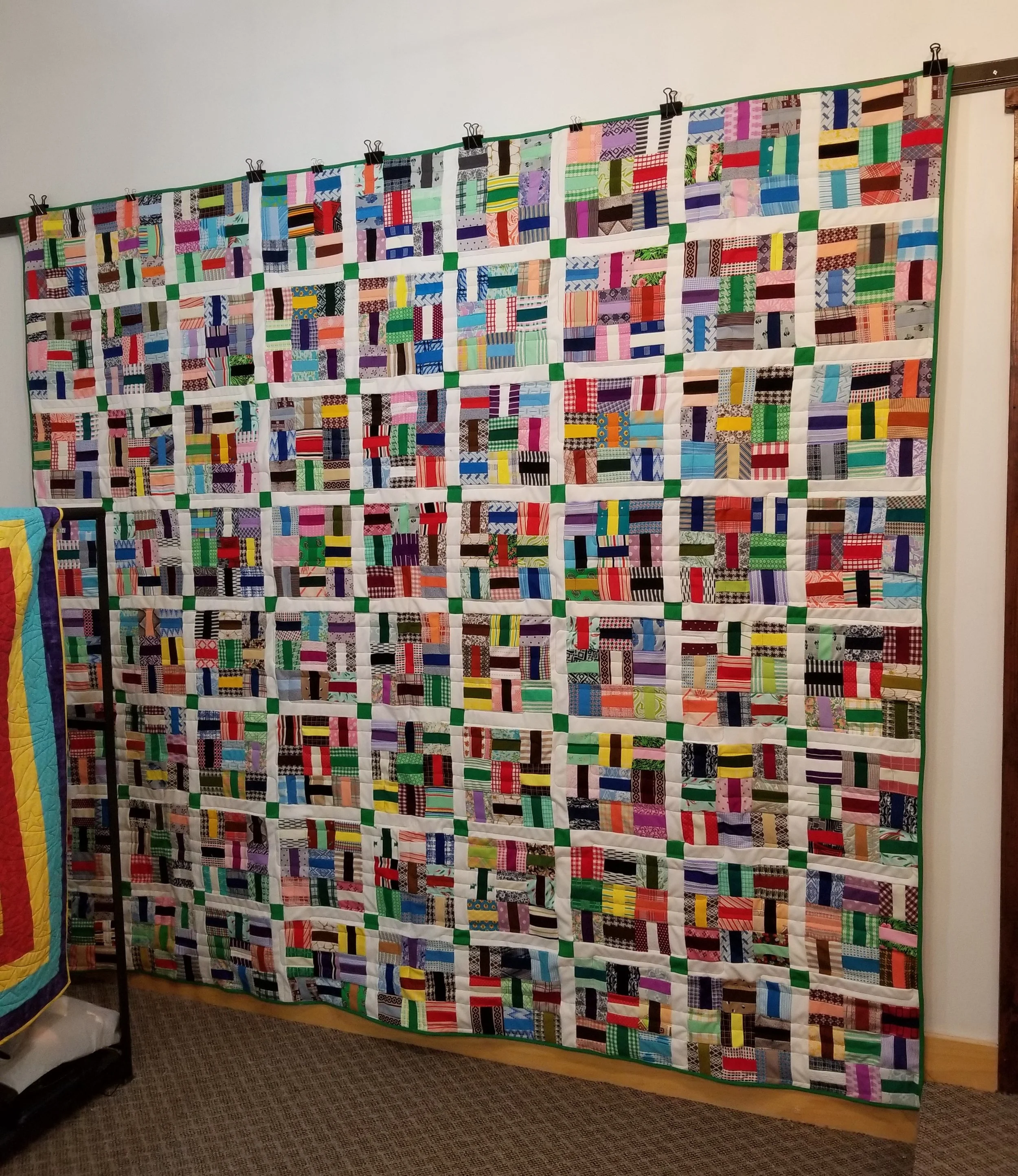 This quilt so heavy, we had to use additional clips to hang from the bar.