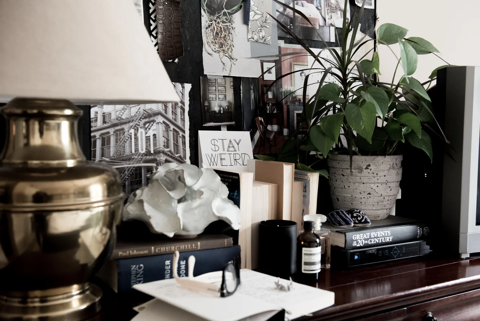 A thrifted brass lamp blends seamlessly with tv components and books.