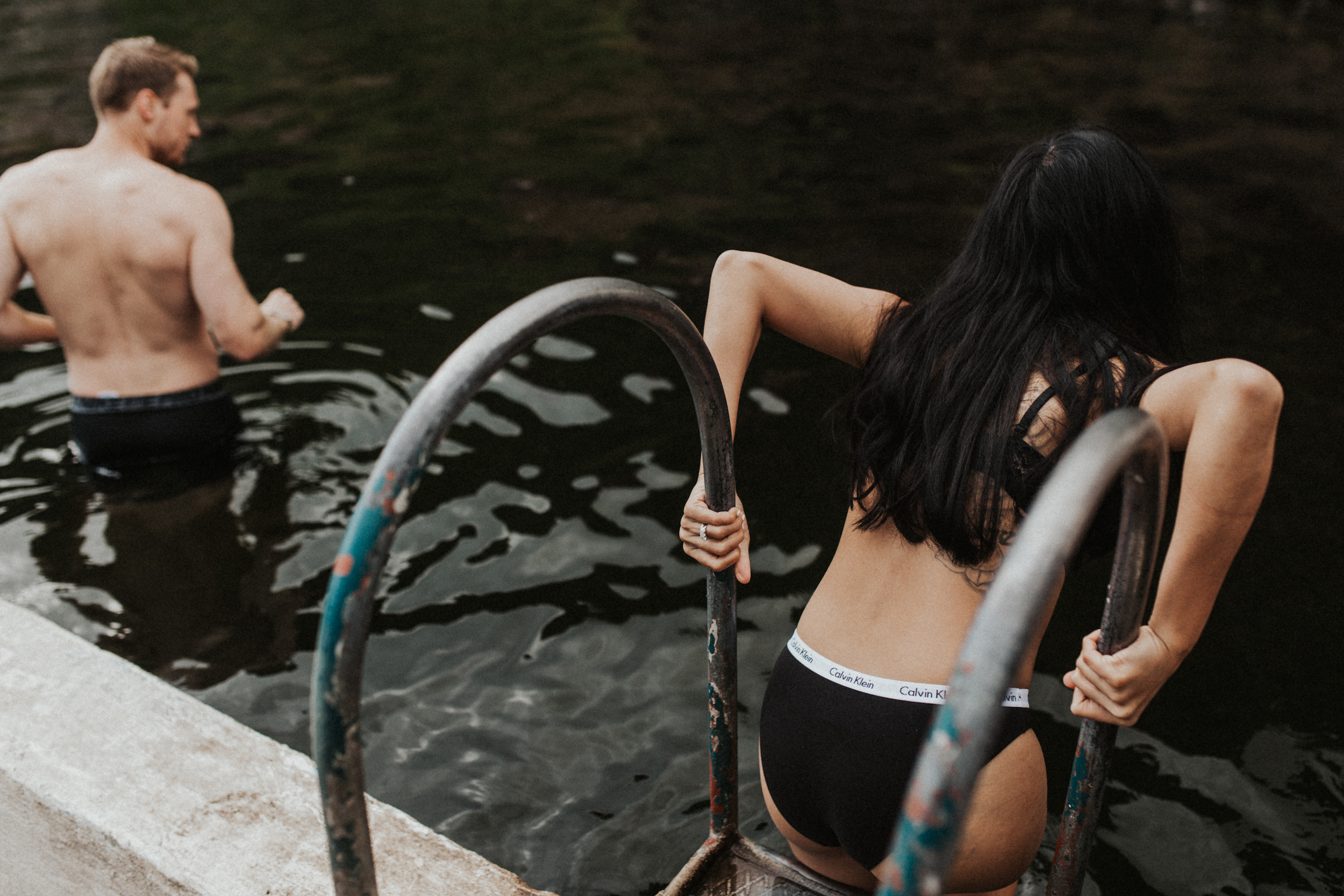 Couple climbing into Seljavallalaug hot springs Iceland.jpg