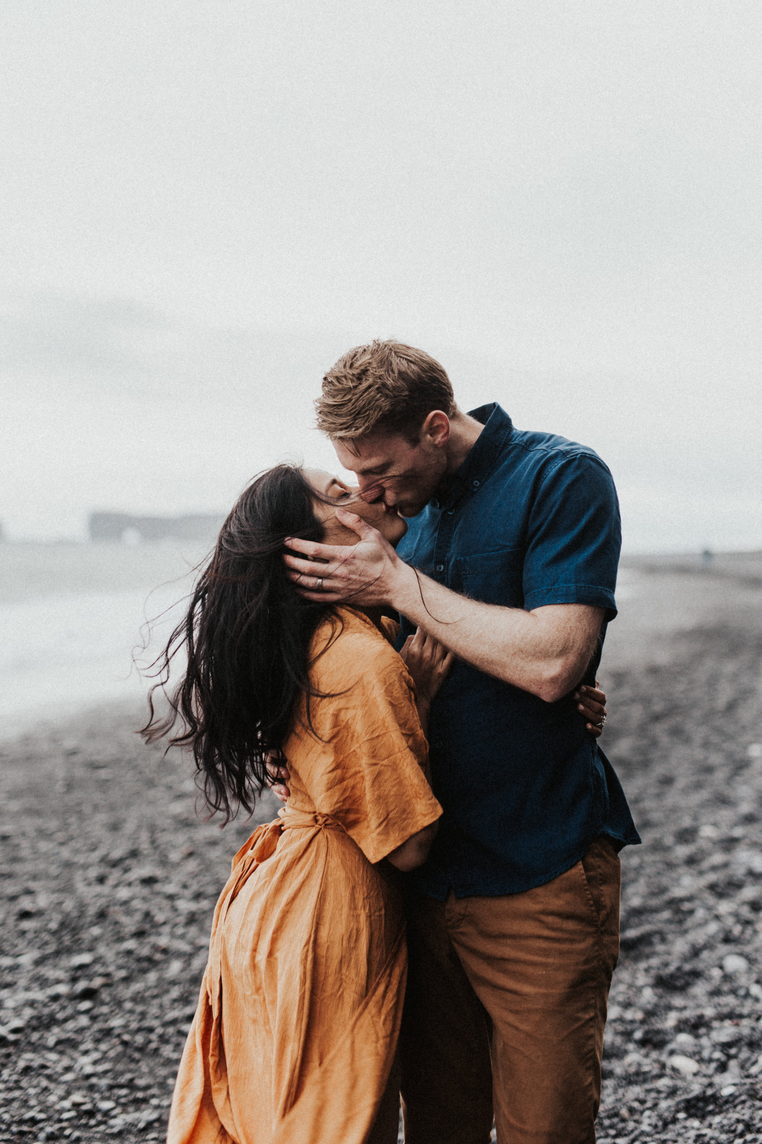 couple kissing on black rocks at vik beach in iceland.jpg