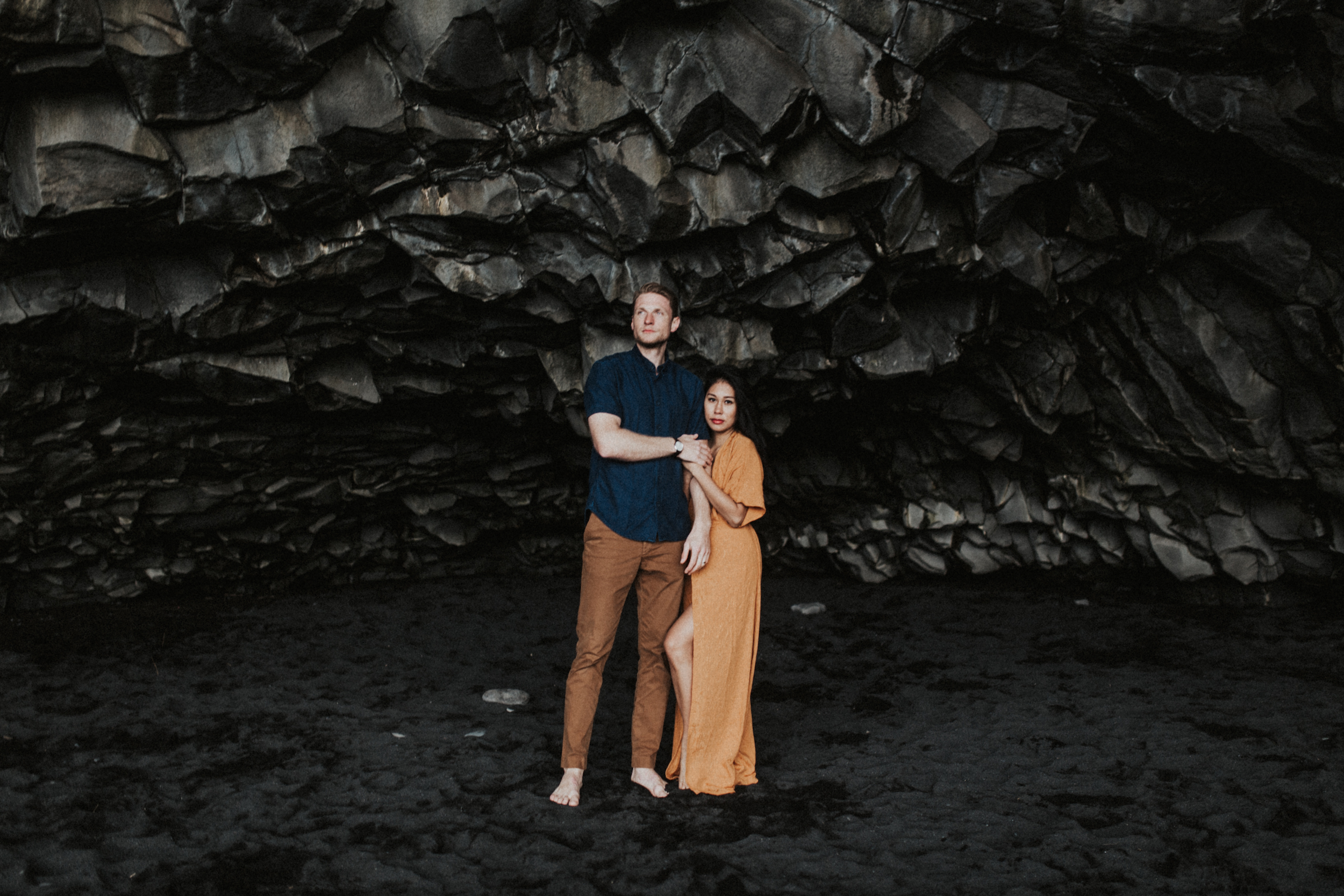 Stunning couple in orange dress and blue shirt in Icelandic caves in Vik.jpg