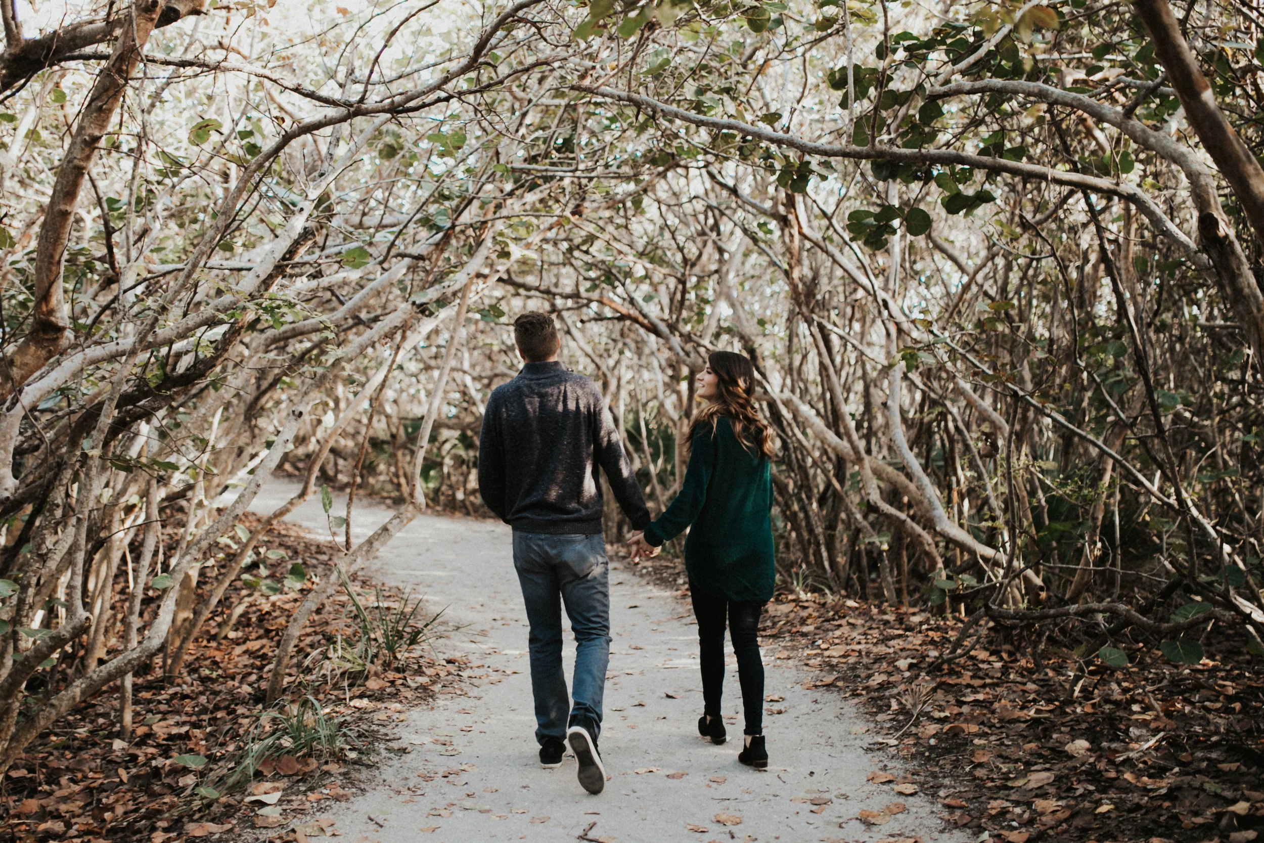 Couple walking through Florida shrubs.jpg