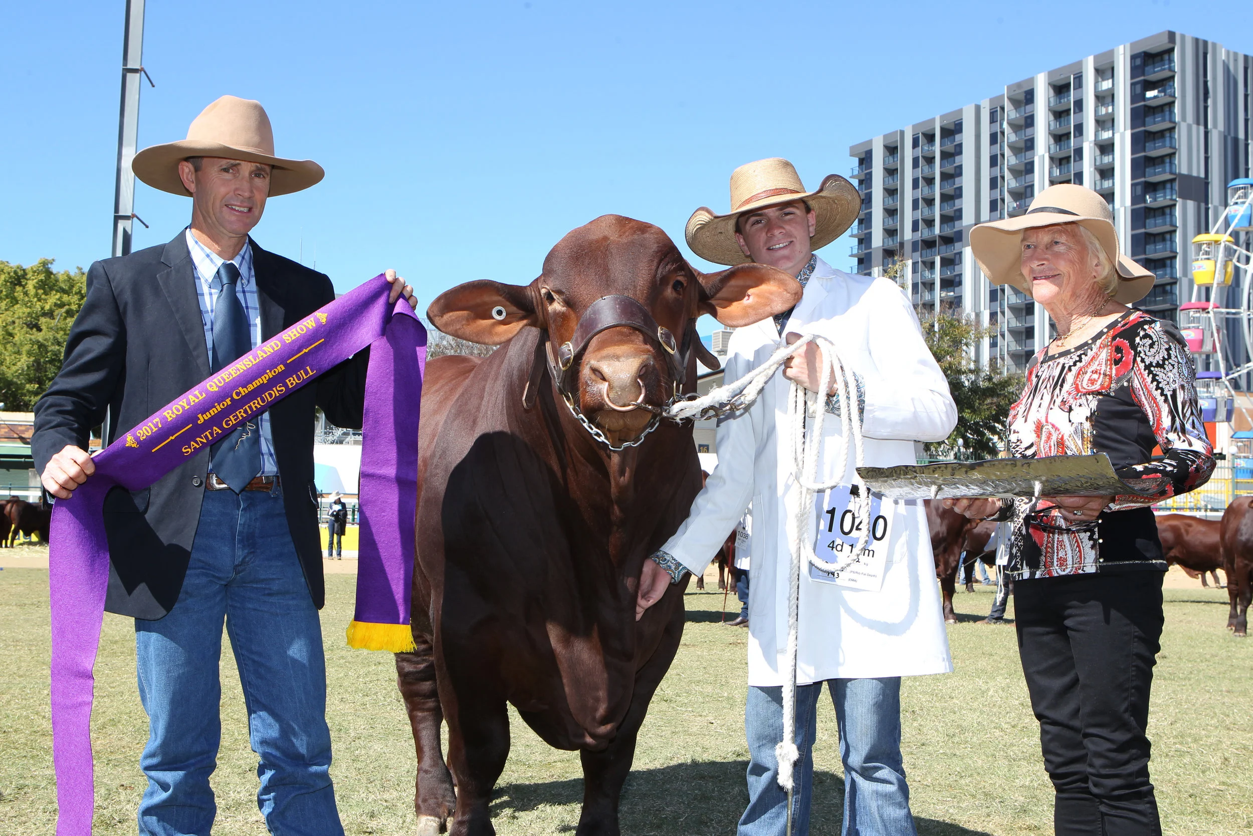 Yarrawonga Gamer M518 (P)- Junior Champion Bull awarded the Eidsvold Station trophy sponsored by Rick and Alice Greenup. Ribbon presented by Rick Greenup, Trophy presented by Mrs Sally Coates and bull led by Jack McGee. 