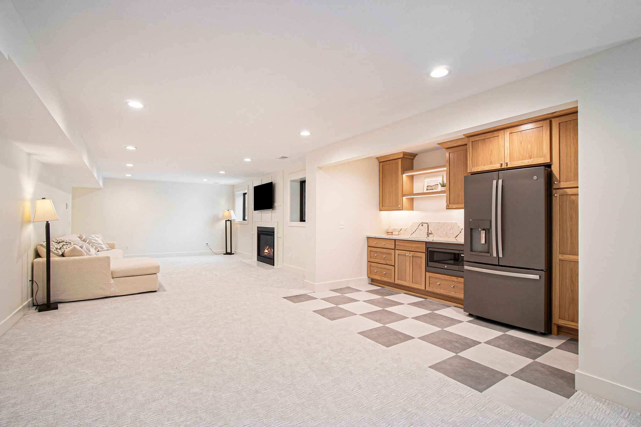 basement kitchenette. checkered floor. stained cabinetry. bright basement.jpg