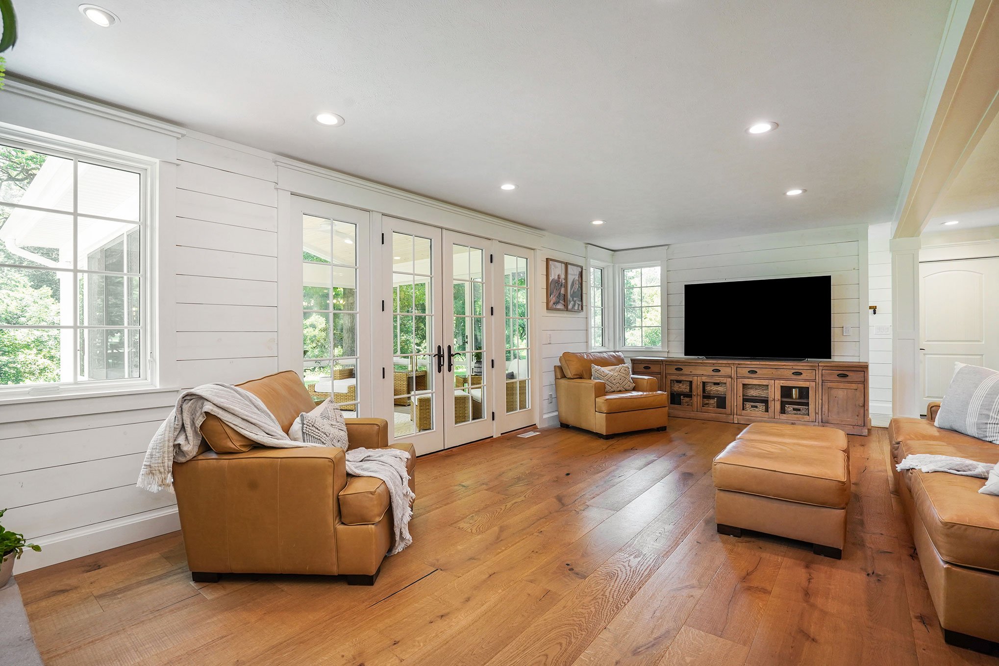 living room. hardwood floor. large windows. leather couches.jpg