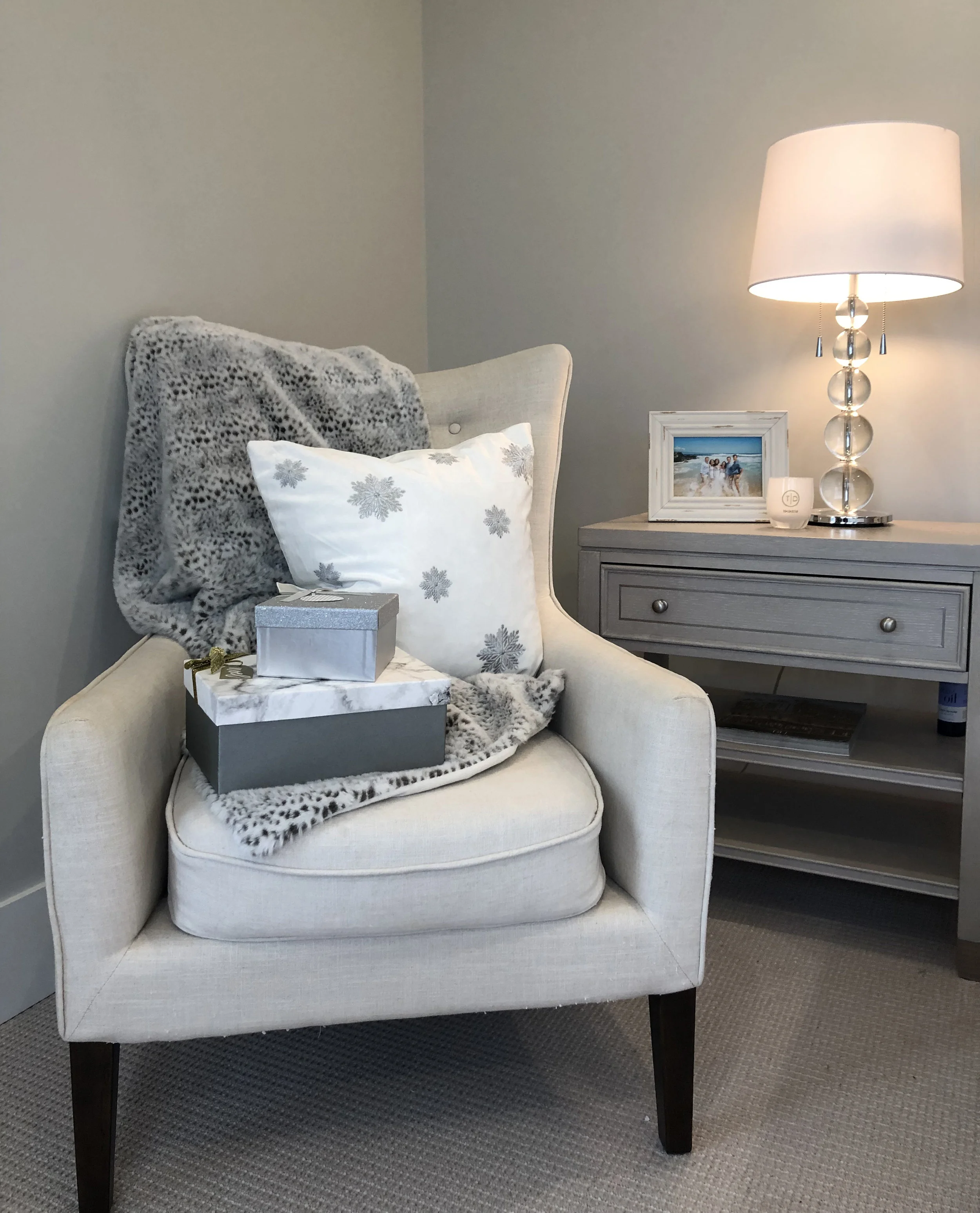 Cozy blankets and wrapped gifts draped on a comfy chair.