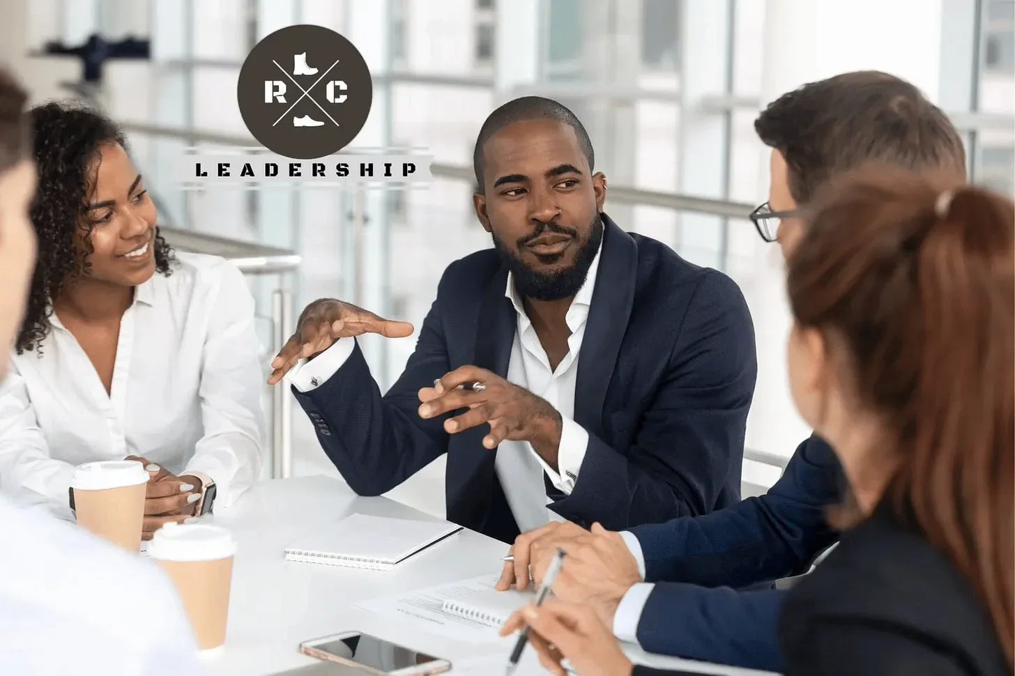 Group of leaders at a table discussing the C of CEO