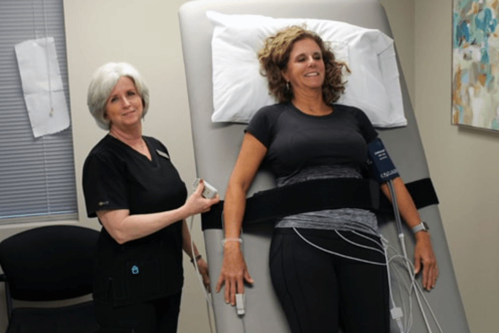 Two women doing a tilt table test to test for POTS, a form of dysautonomia..