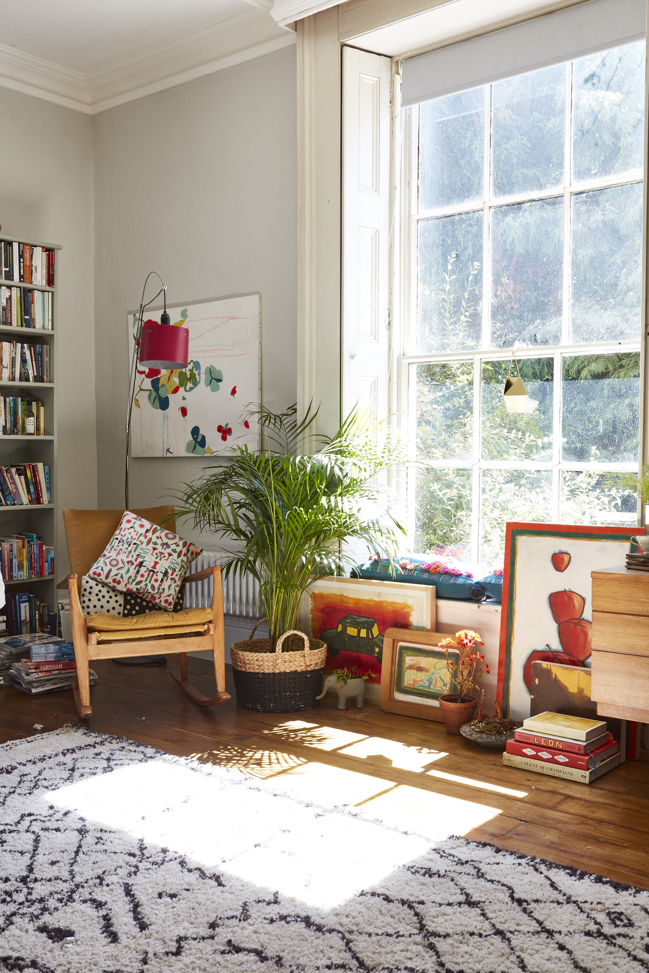 Rocking chair – Original Parker Knoll bought at auction. Rug from La Redoute . Basket with plant inside, H+M . Selection of artwork by Irish artist Joby Hickey and Irish fashion illustrator Emma Sheridan. Elephant planter and cushions in window sill, Anthropologie Red hanging lamp, Habitat Walls painted in Ammonite from Farrow and Ball