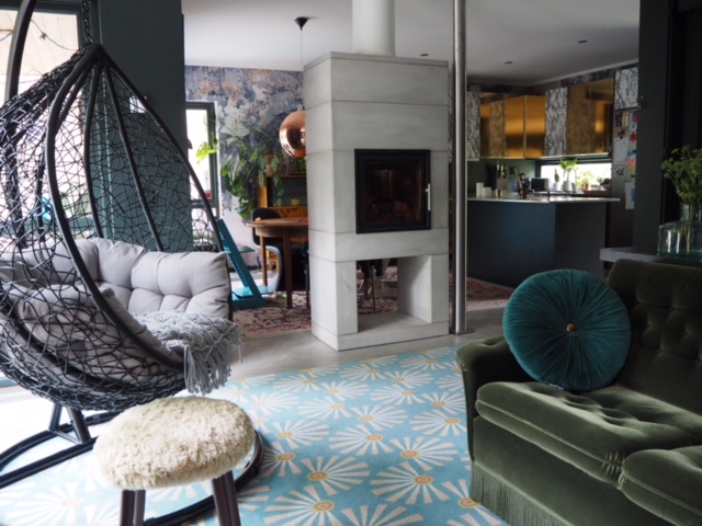 Maria covered the kitchen cabinets, once white, with marble and gold. The green velvet sofa was a vintage find.
