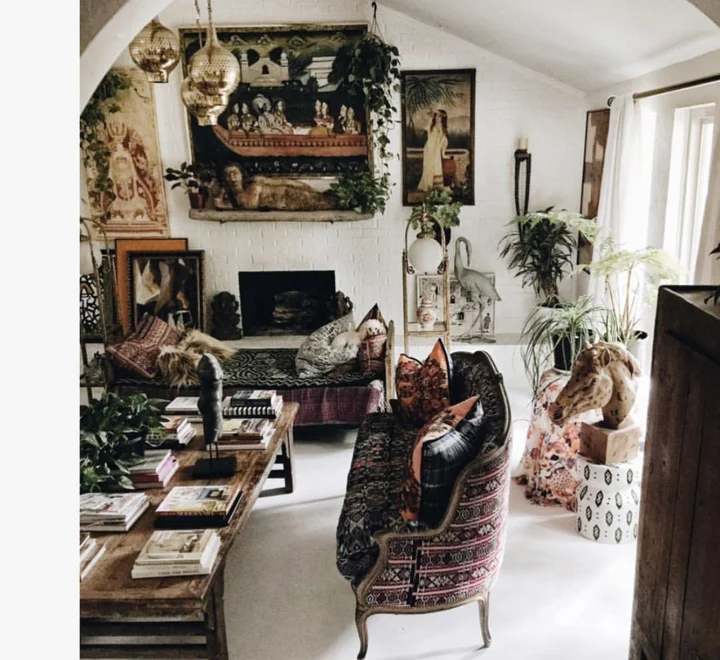 The Living Room. This is a great example of how Judy pulls off her unique style. I love that your eye does not know what to look at first; the art, the textiles, the horses head or the piles of books on the table. Gorgeous sofas and furniture, plants all add to the boho look.