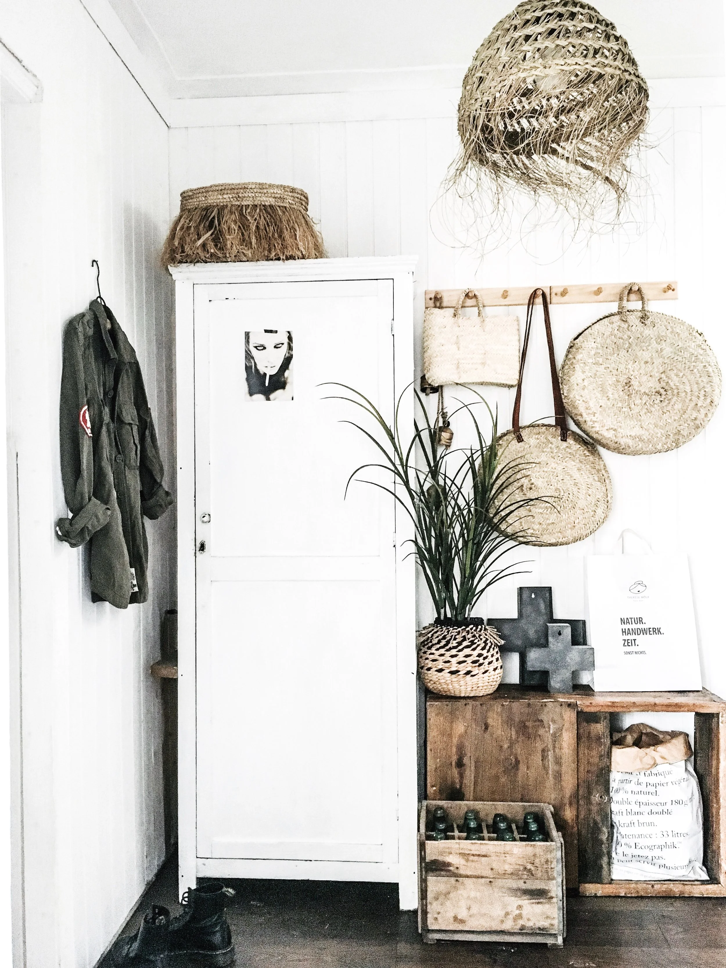 Kate's hallway, where a vintage cupboard sits beautifully against natural wood, rustic boxes and wicker baskets, a masterclass in texture
