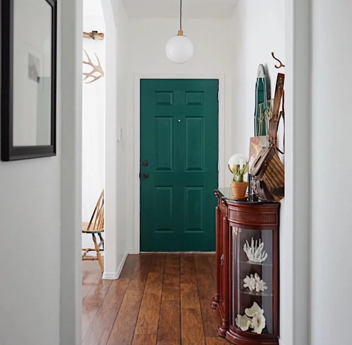 A long thin hallway, set of beautifully by this vibrant green door; it used to be pink.