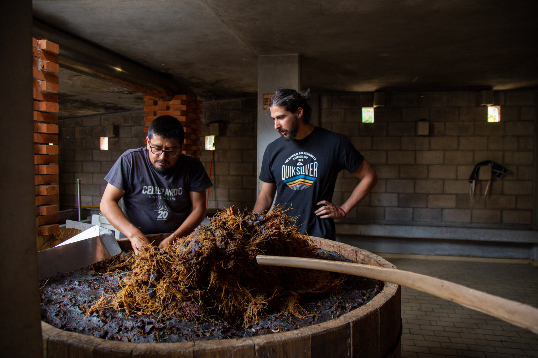 Oscar and Jorge transfer fermented agave into copper stills.