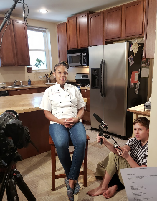On set interviewing with audio gear, cameras and script ready.