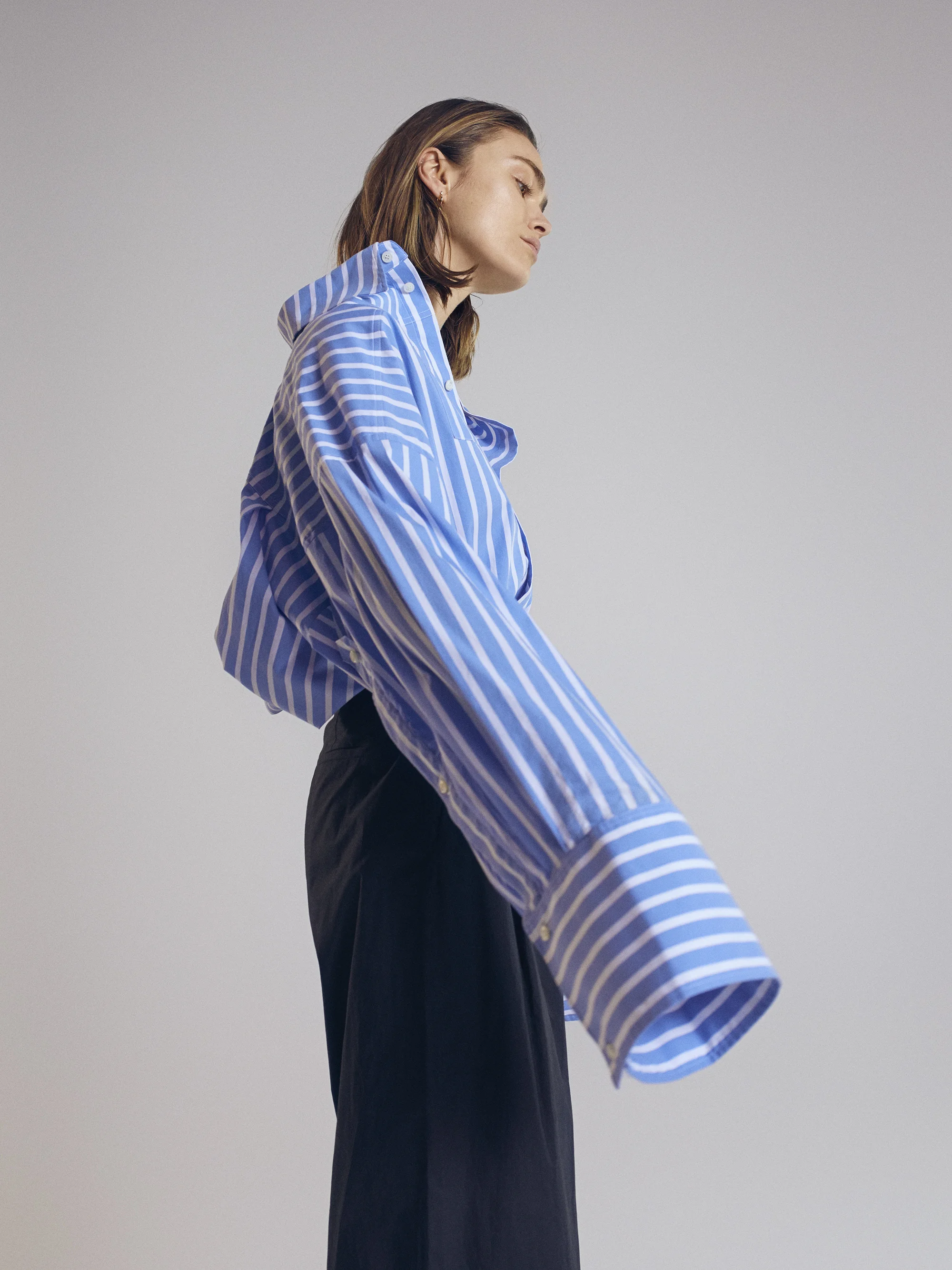 Oversized striped shirt Schuellerdewaal . Pleated trousers Tse. Earring Cos