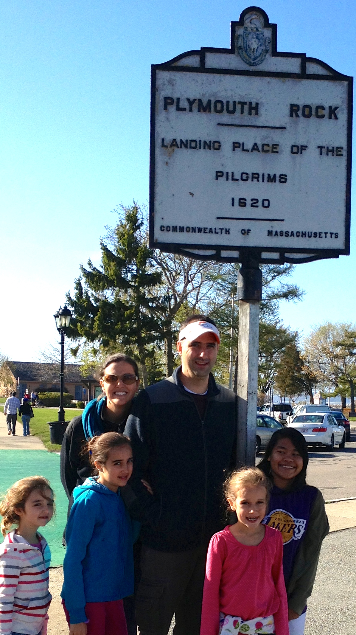 The fam standing in front of the sign marking Plymouth Rock. 