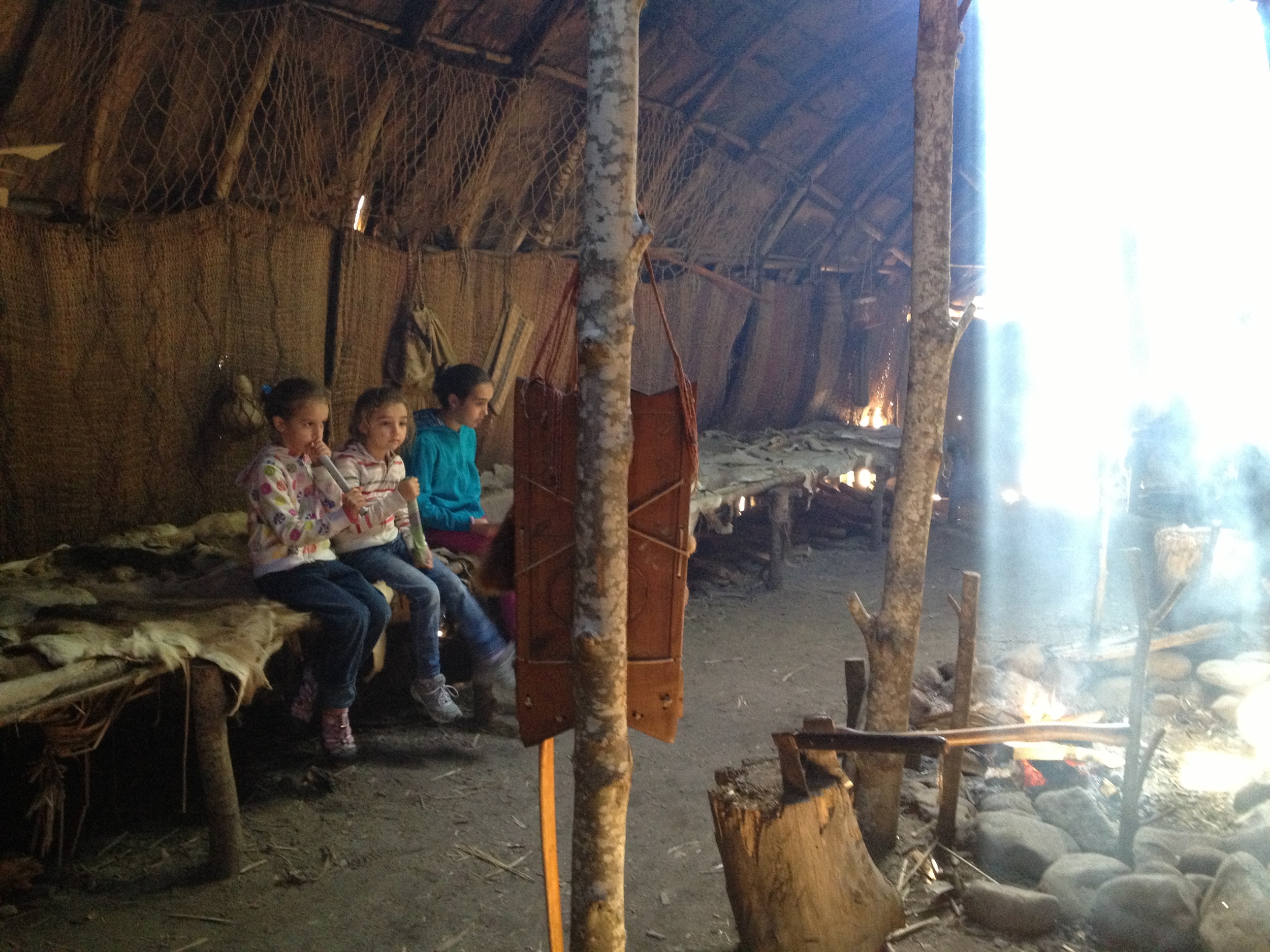 The girls inside a Wampanoag home learning from a Wampanoag descendent of their way of life in the 1600s. 