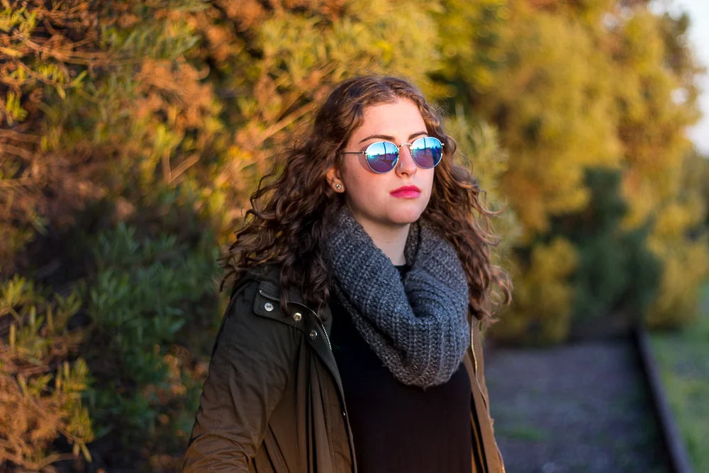 Senior Girl with sunglasses and multi colored foliage behind her