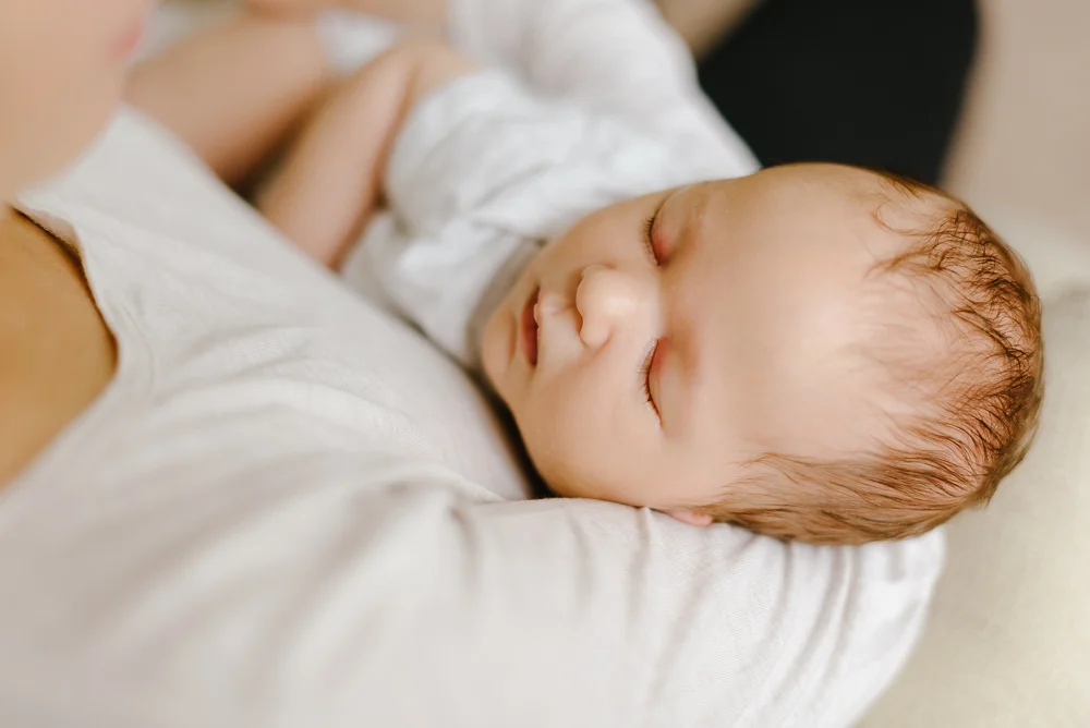 mom holding newborn baby in the rocking chair