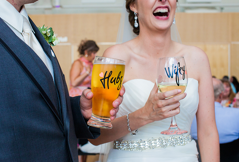 Columbus-Indiana-wedding-photographer-bride-and-groom-holding-custom-glasses-wifey-hubs.jpg