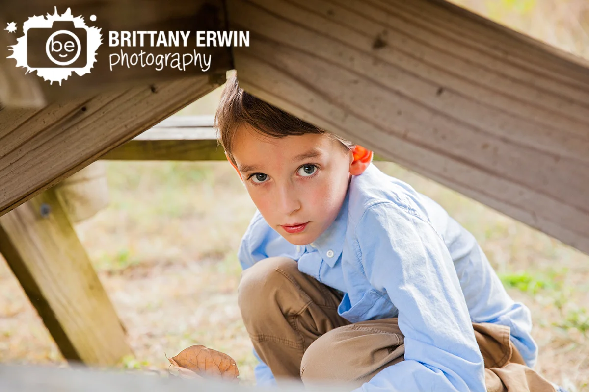 Outdoor-portrait-photographer-Zionsville-Indiana-boy-playing-under-picnic-table.jpg
