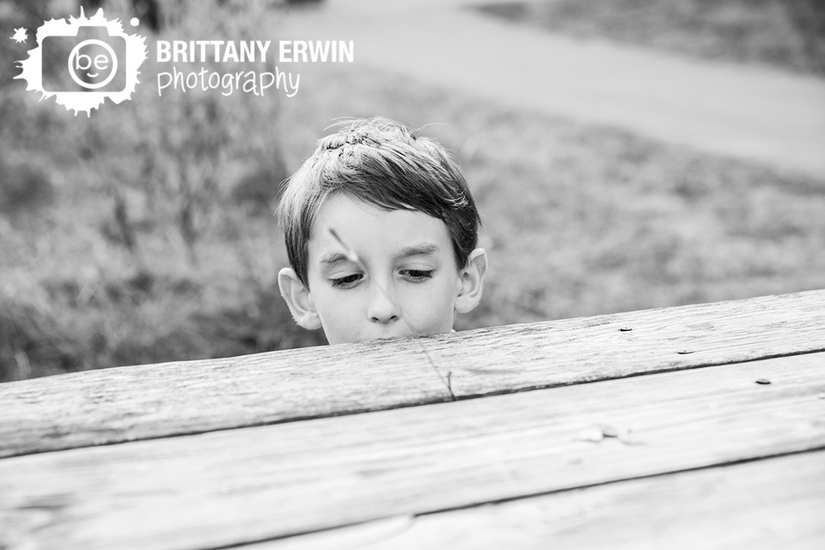 boy playing with grass and park table
