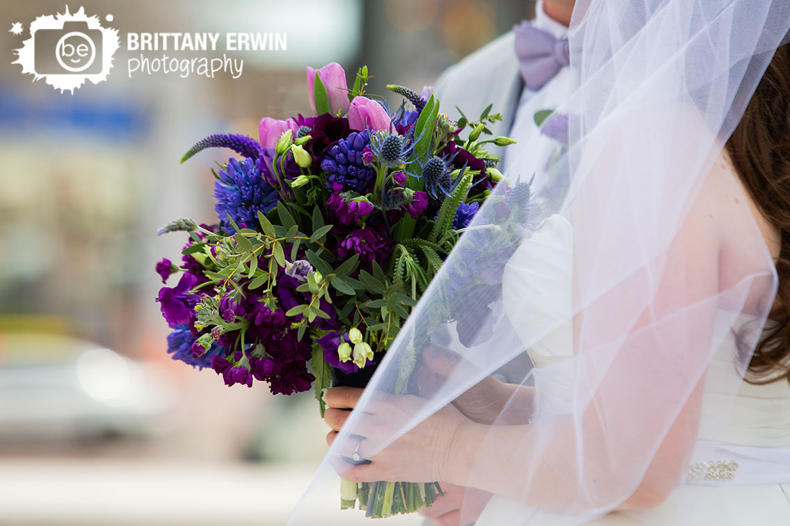 Downtown-Indianapolis-wedding-photographer-bride-holding-violets-are-blue-purple-bouquet-thistle-tulips.jpg