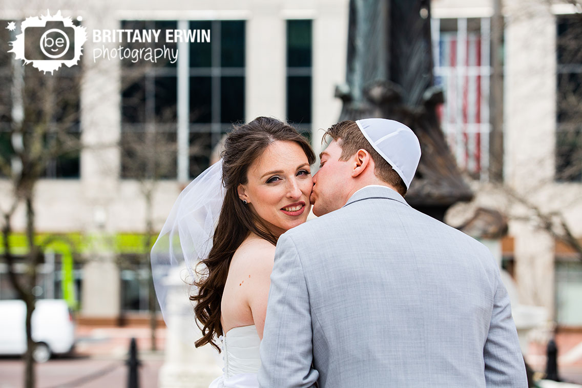 Downtown-Indianapolis-wedding-photographer-cheek-kiss-couple-on-monument-circle.jpg
