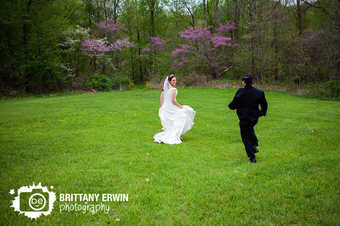 Clayshire-Castle-wedding-photographer-couple-running-through-field-redbud-trees.jpg