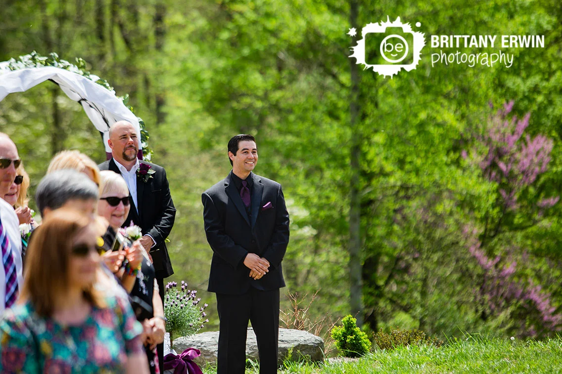 Outdoor-wedding-ceremony-at-Clayshire-Castle-in-Indiana-groom-reaction-seeing-bride-first-time.jpg