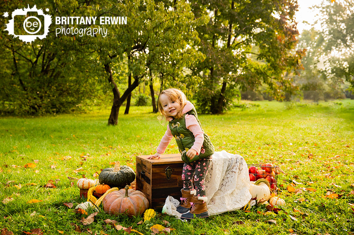 Indianapolis-fall-mini-session-little-girl-vest-pink-shirt-pumpkin-apples.jpg