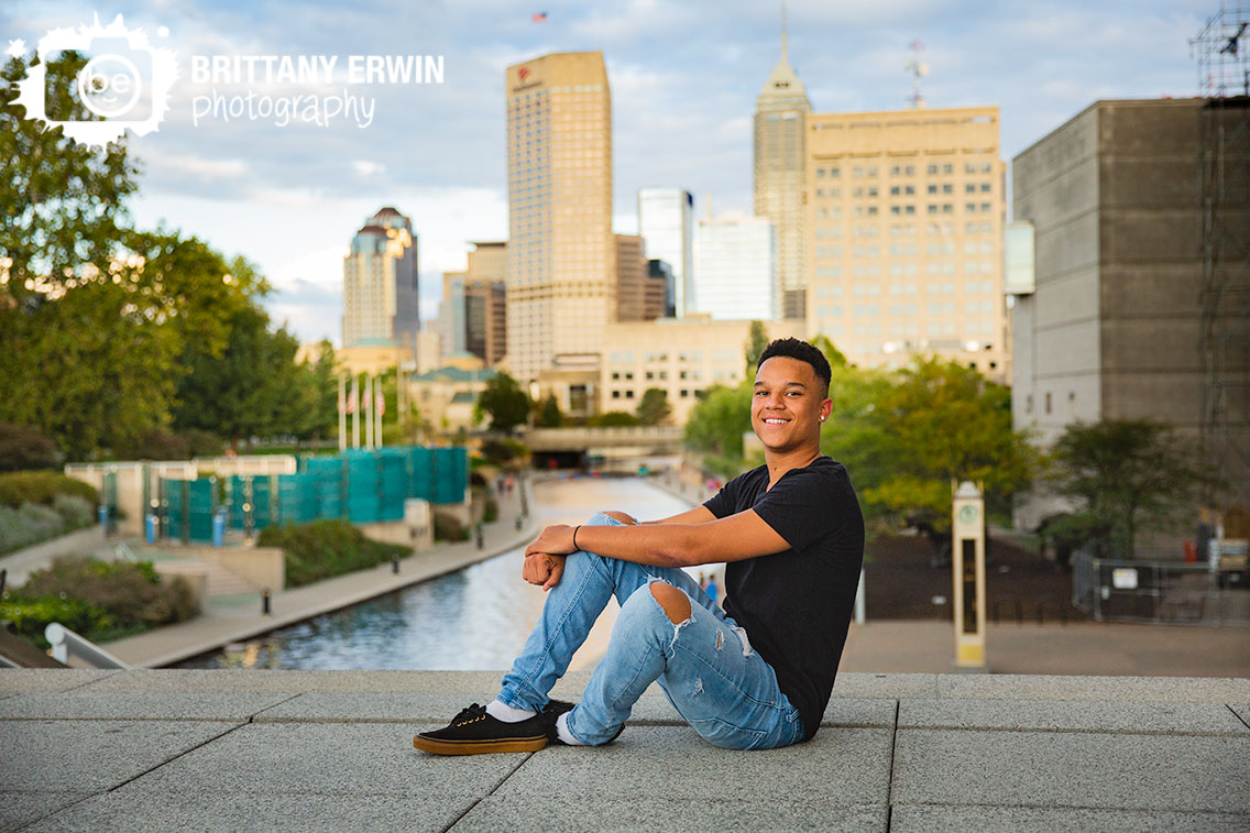 Downtown-Indianapolis-skyline-high-school-senior-portrait-photographer-sitting-at-top-of-stairs-canal-view.jpg