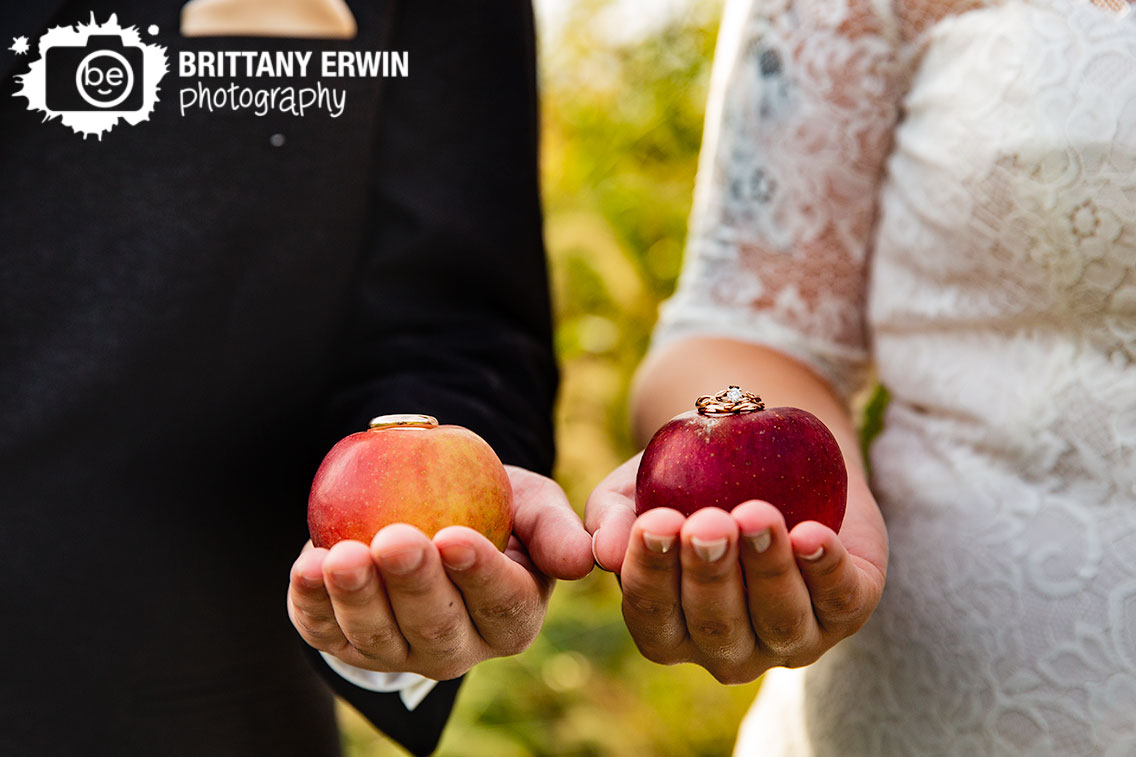 Wea-Creek-Orchard-wedding-photographer-apple-rings-on-fruit-couple-holding-apples.jpg