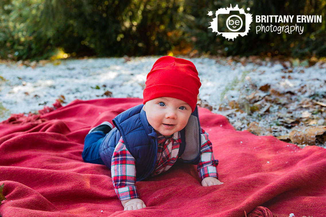 Snow-mini-session-baby-boy-puffy-vest-red-hait-on-belly.jpg