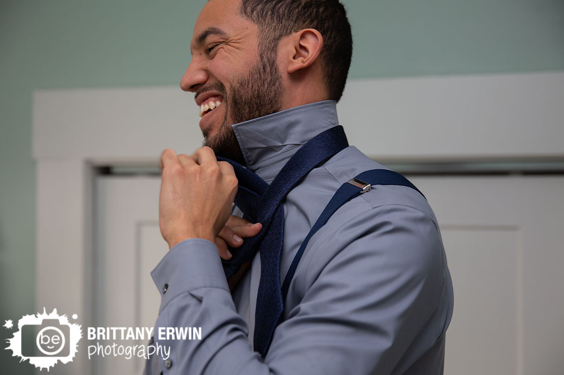 Indianapolis-groom-getting-ready-tying-tie-laughing-elopement.jpg