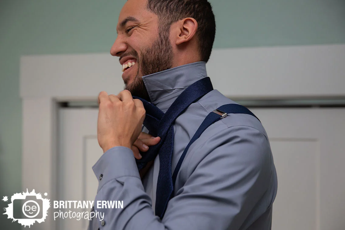 Indianapolis-groom-getting-ready-tying-tie-laughing-elopement.jpg