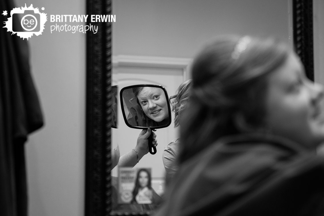 Indianapolis-wedding-photographer-bride-looking-at-hair-in-mirror-salon-and-spa-no-7.jpg
