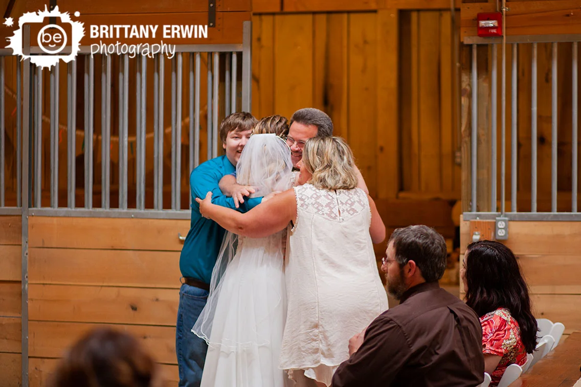 Indiana-wedding-photographer-bride-and-groom-group-hug-release-by-row-at-ceremony.jpg