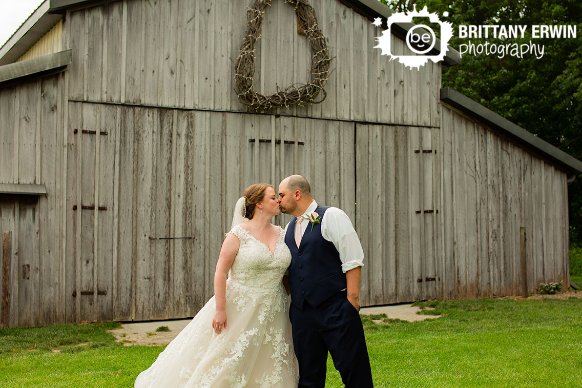 Hidden-Brook-Acres-barn-wreath-over-doors-couple-kiss.jpg