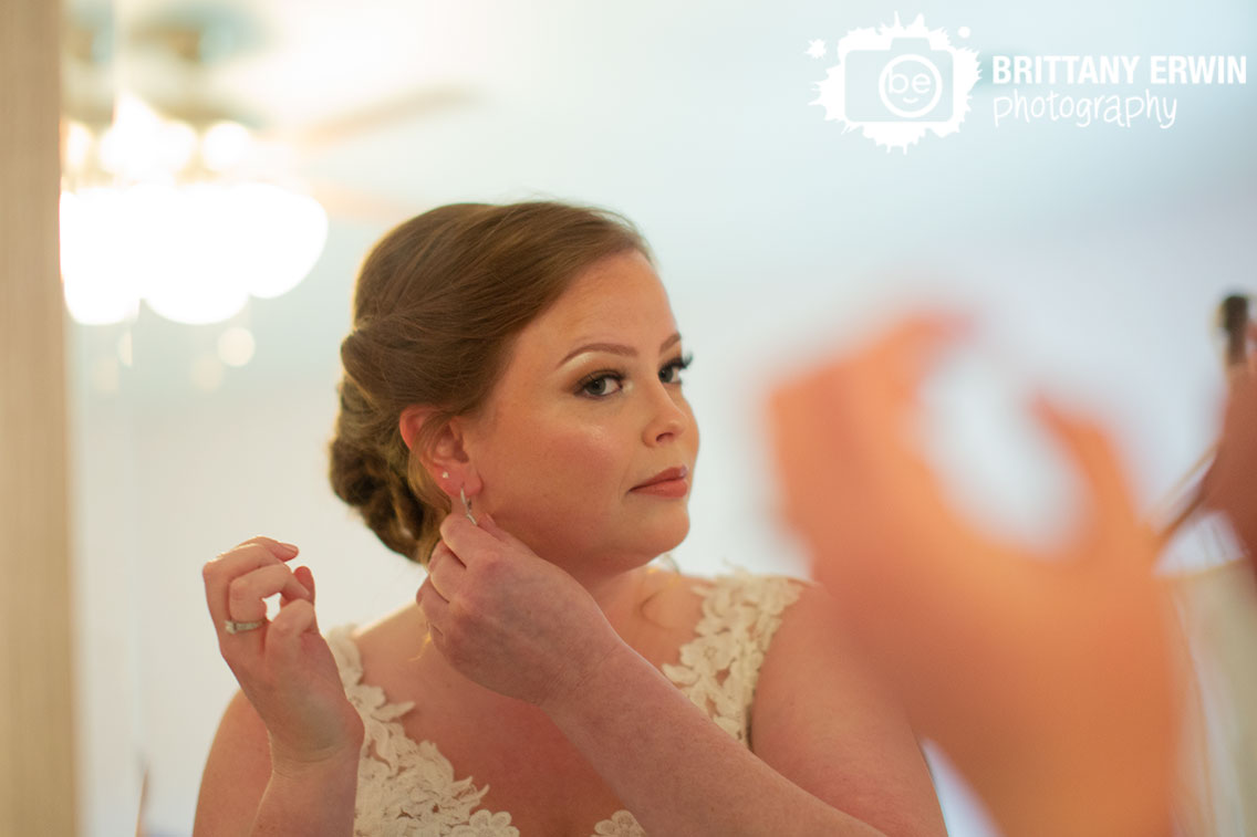 Indiana-wedding-photographer-bride-getting-ready-put-on-earrings-in-mirror.jpg