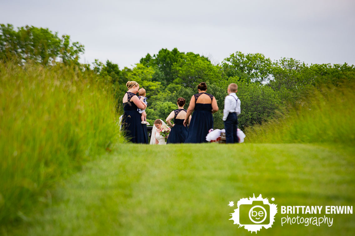 bride-walking-up-to-ceremony-space-bridesmaids-waiting.jpg