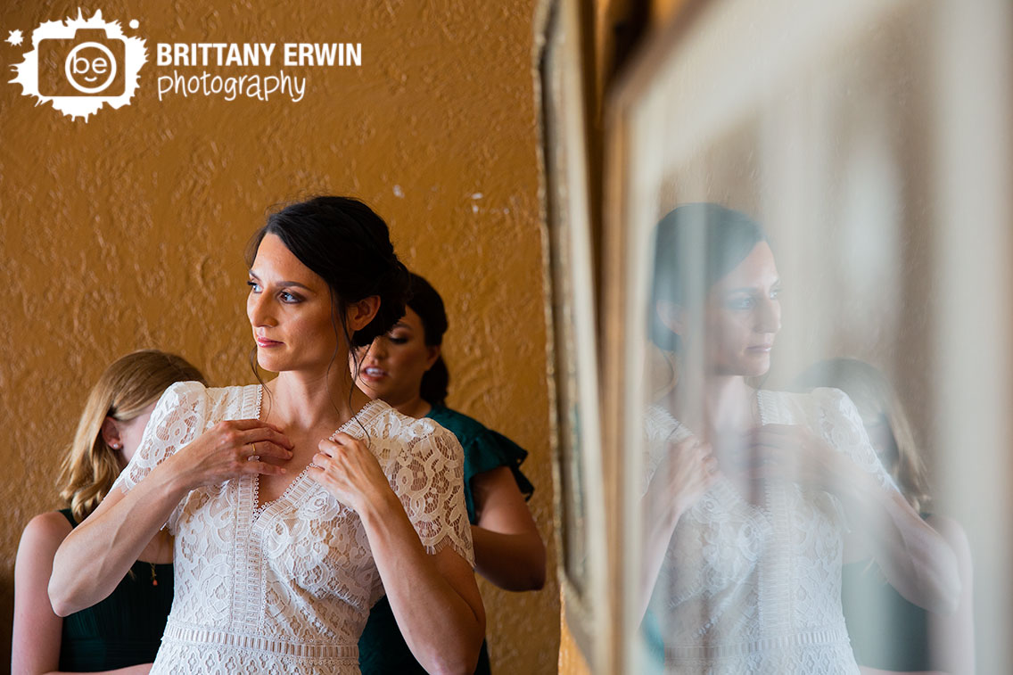 Bride-putting-on-dress-reflection-in-picture.jpg