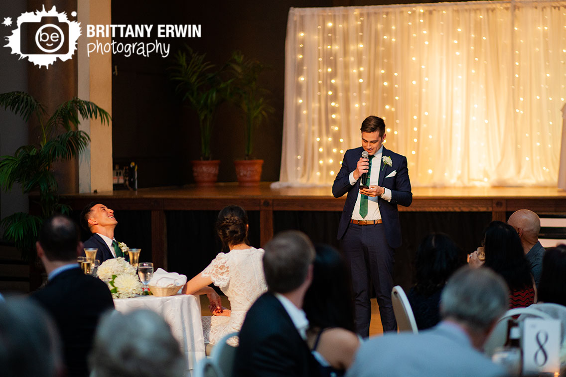 Best-man-giving-toast-at-wedding-reception-groom-laugh-reaction.jpg