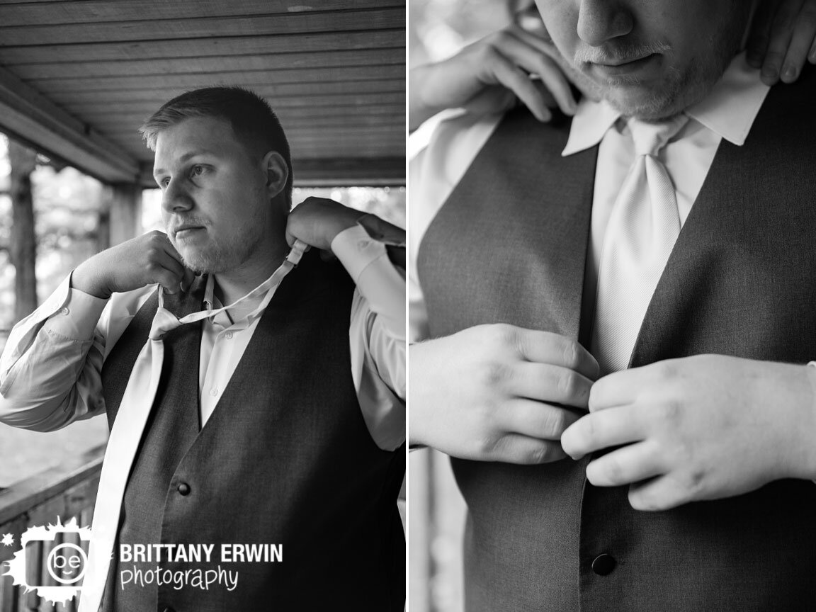 groom-getting-ready-putting-on-tie-button-vest.jpg