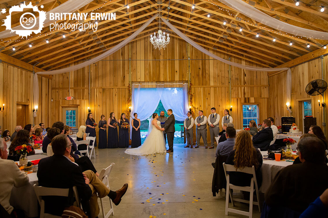 Indiana-barn-wedding-photographer-couple-at-altar-ceremony-white-drapery.jpg