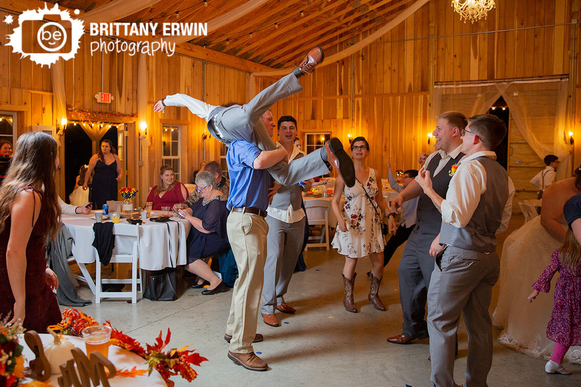 dance-floor-dancing-groomsman-on-shoulders-barn-wedding.jpg