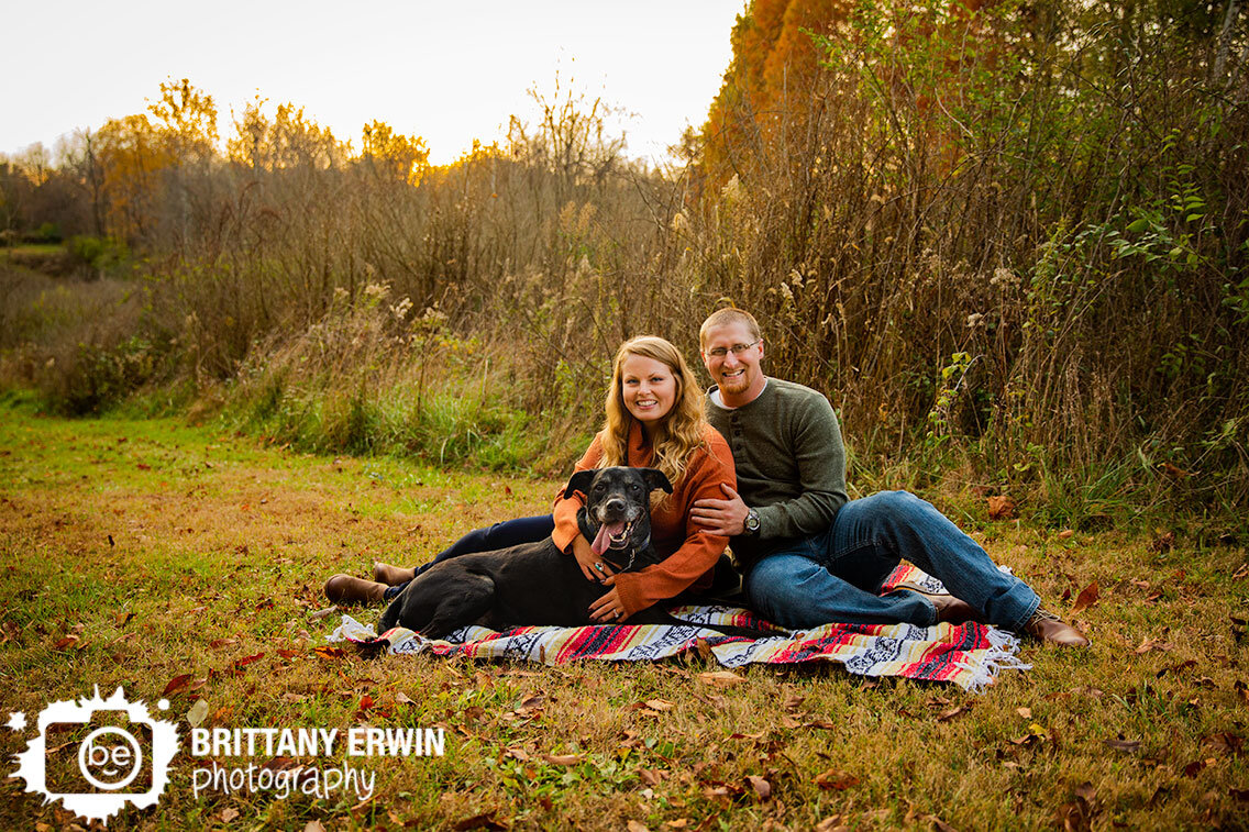 engagement-photographer-couple-with-pet-dog-fall-portrait-on-blanket-in-path-at-sunset.jpg