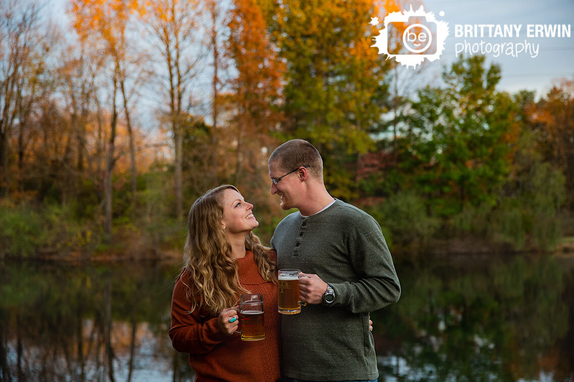 couple-sharing-a-beer-by-a-pond-fall-engagement-session.jpg